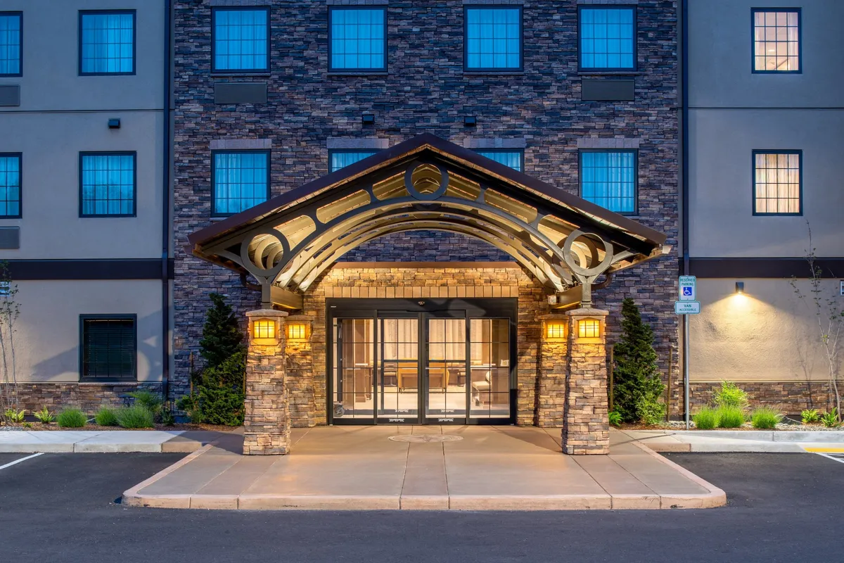 This image showcases the hotel's arched entrance with a stone facade and decorative light fixtures, creating a sense of arrival. The entrance area is designed to be welcoming, evoking feelings of comfort and togetherness as guests arrive or prepare to explore nearby attractions.